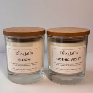 Two DitsyJaffa clear glass candles with wooden lids containing Bloom and Gothic Violet scents, showing the hand-poured coconut and rapeseed wax details on the labels.