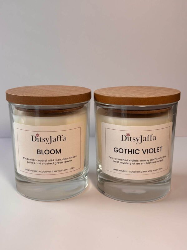Two DitsyJaffa clear glass candles with wooden lids containing Bloom and Gothic Violet scents, showing the hand-poured coconut and rapeseed wax details on the labels.