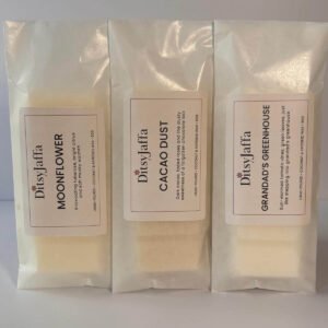 Threee DitsyJaffa wax melt snap bars in glassine bags containing Grandad's Greenhouse, Cacao Dust and Moonflower scents, showing the hand-poured coconut and rapeseed wax details on the labels.