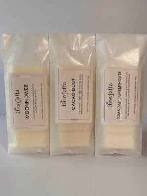 Threee DitsyJaffa wax melt snap bars in glassine bags containing Grandad's Greenhouse, Cacao Dust and Moonflower scents, showing the hand-poured coconut and rapeseed wax details on the labels.