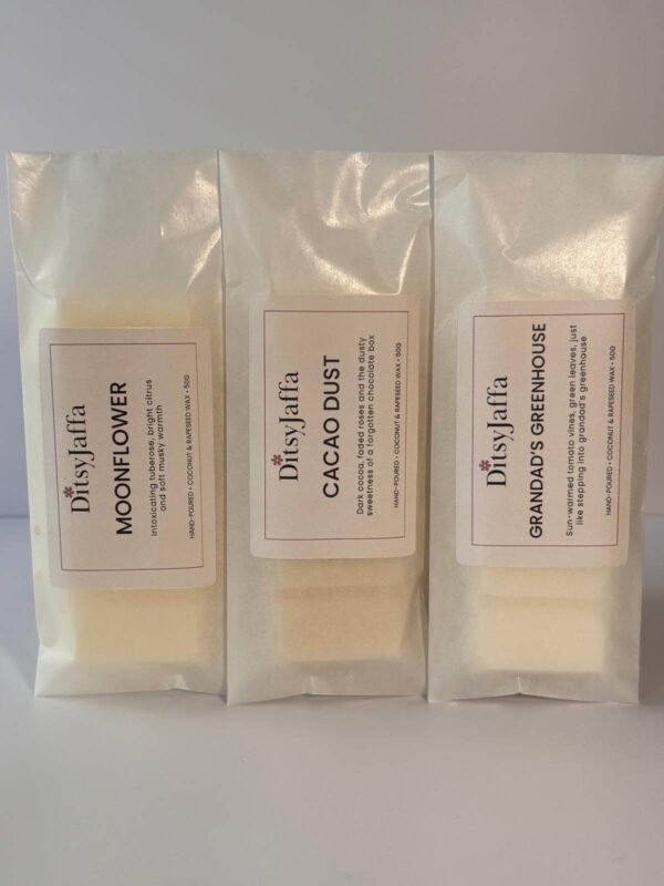 Threee DitsyJaffa wax melt snap bars in glassine bags containing Grandad's Greenhouse, Cacao Dust and Moonflower scents, showing the hand-poured coconut and rapeseed wax details on the labels.